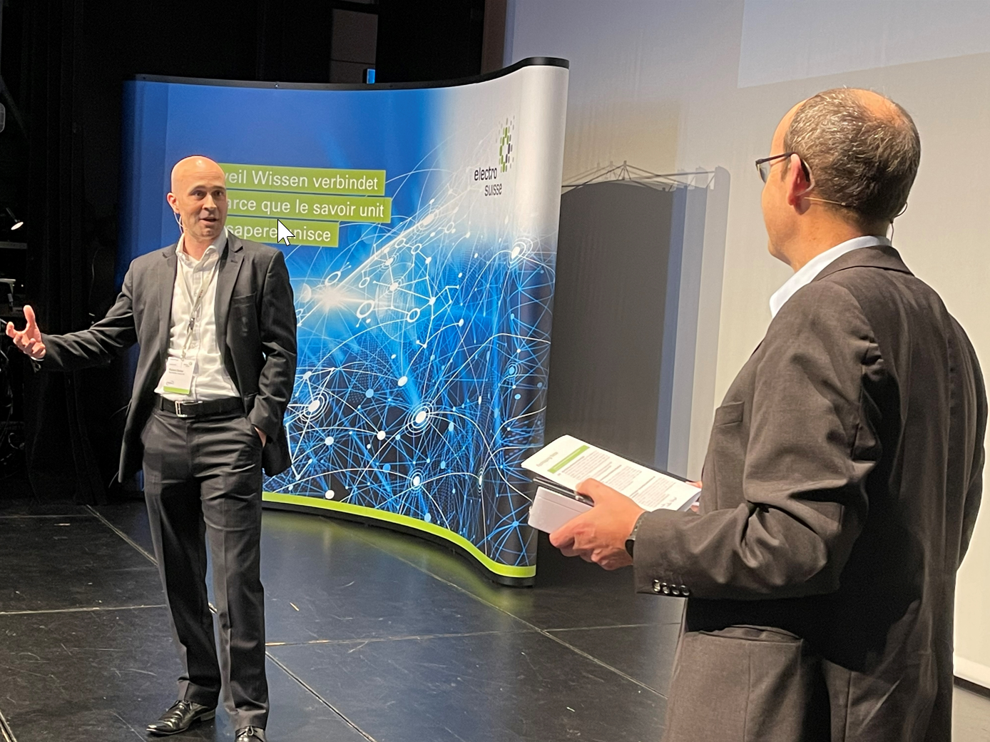 Robert Seiler, Director Corporate Strategy bei Mobility House, mit Moderator Lukas Küng von Primeo Energie (v. l.).